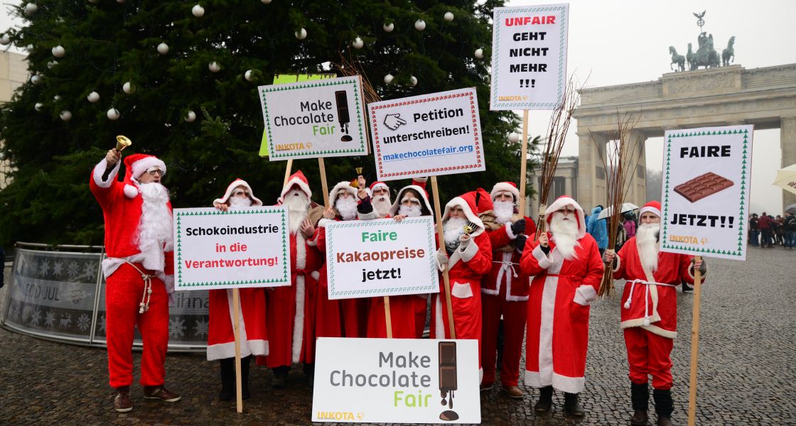 Gruppe von Menschen als Weihnachtsmänner verkleidet demonstrieren vor dem Brandenburger Tor in Berlin