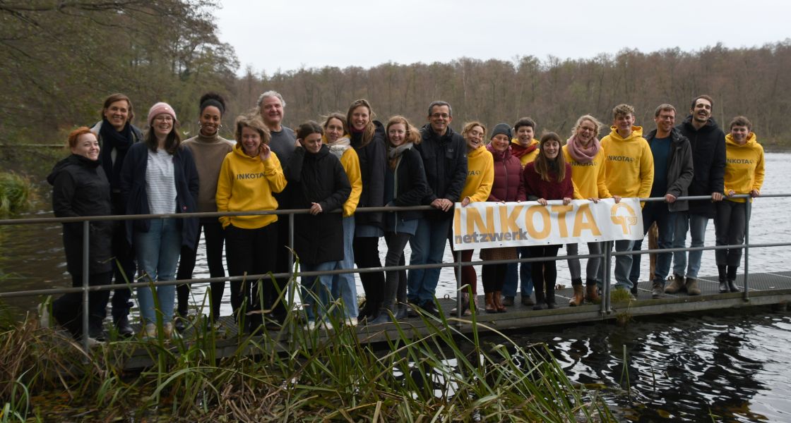 Inkota-Mitarbeiter*innen stehen auf einem Steg an einem See