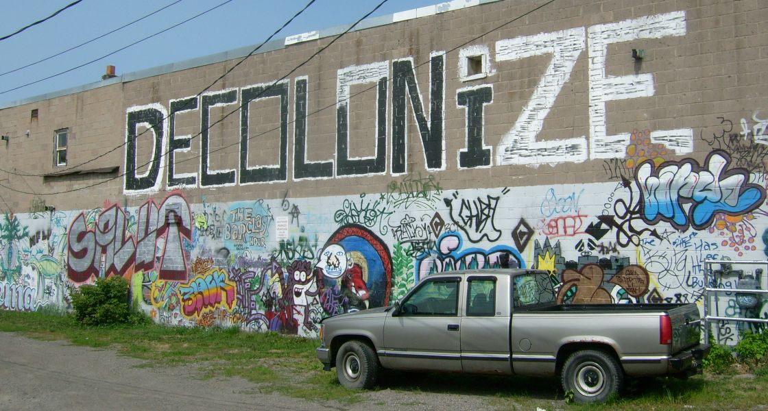 Besprühte Wand mit Schriftzug Decolonize