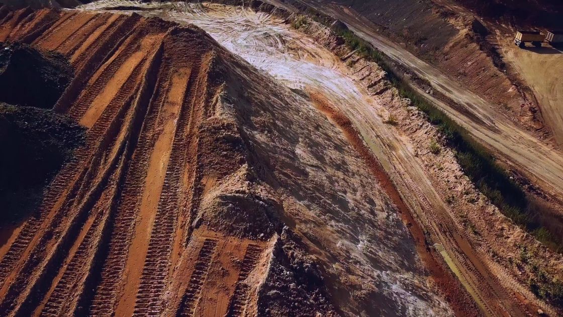 Draufsicht auf einen Sandsteinbruch, in dem viele Radspuren zu sehen sind.