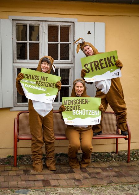 Drei Frauen in Osterhasenkostümen demonstrieren mit Plakaten