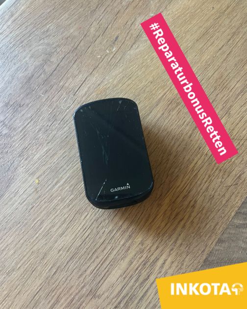 Garmin Fahrradcomputer mit gesprungenem Display liegt auf einem Holztisch