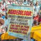 Ein großes Protestplakat und dahinter eine große Menschenmenge