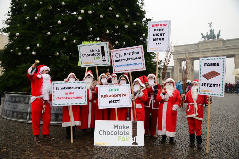 Gruppe von Menschen als Weihnachtsmänner verkleidet demonstrieren vor dem Brandenburger Tor in Berlin