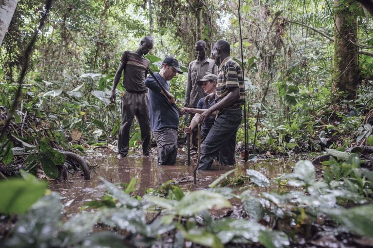 Menschengruppe entnimmt Proben aus einem Moor