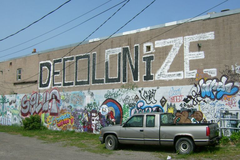 Besprühte Wand mit Schriftzug Decolonize